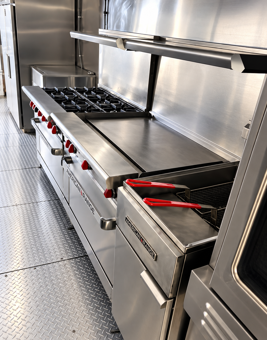 Range, griddle and fryer line inside a 38 ft mobile kitchen trailer
